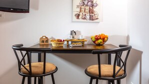 A dining area with a table, chairs, a painting, and a fruit bowl. - Le Vigne - Appartamento Giardini (Bolsena)