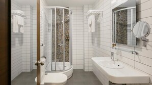A bathroom with a shower, toilet, sink, and a mirror. - Ginger Hotel (Tbilisi)
