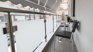 A balcony with a metal railing, a table, and a chair. - Central Cozy Home by Rentals Pro - Nea Moudania Halkidiki (Nea Moudania)