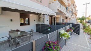 Un immeuble d’habitation doté d’un balcon, d’un espace extérieur aménagé pour s’asseoir et de plantes en pot.