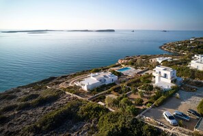 A coastal property with white buildings, a swimming pool, and a parking area. - Seafront Villa Thea -island Living- (Paros)