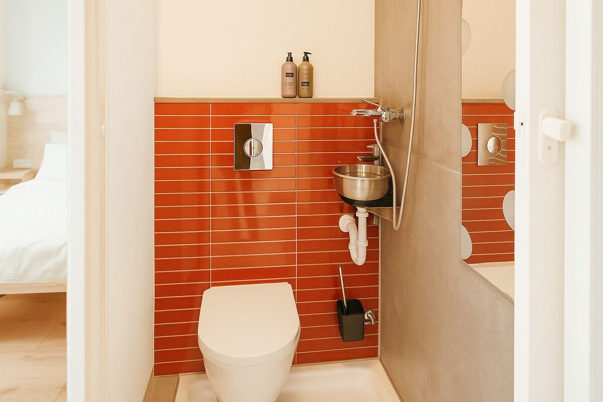 A bathroom with a toilet, a sink, and a mirror. There are toiletries on the wall.
