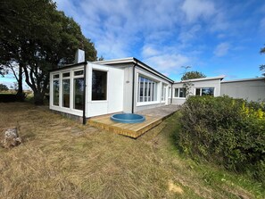 A modern house with a large deck, a swimming pool, and a garden area. - Ægissíða - Renovated Country House (Hella)