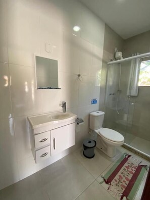 A bathroom with a sink, toilet, and shower.