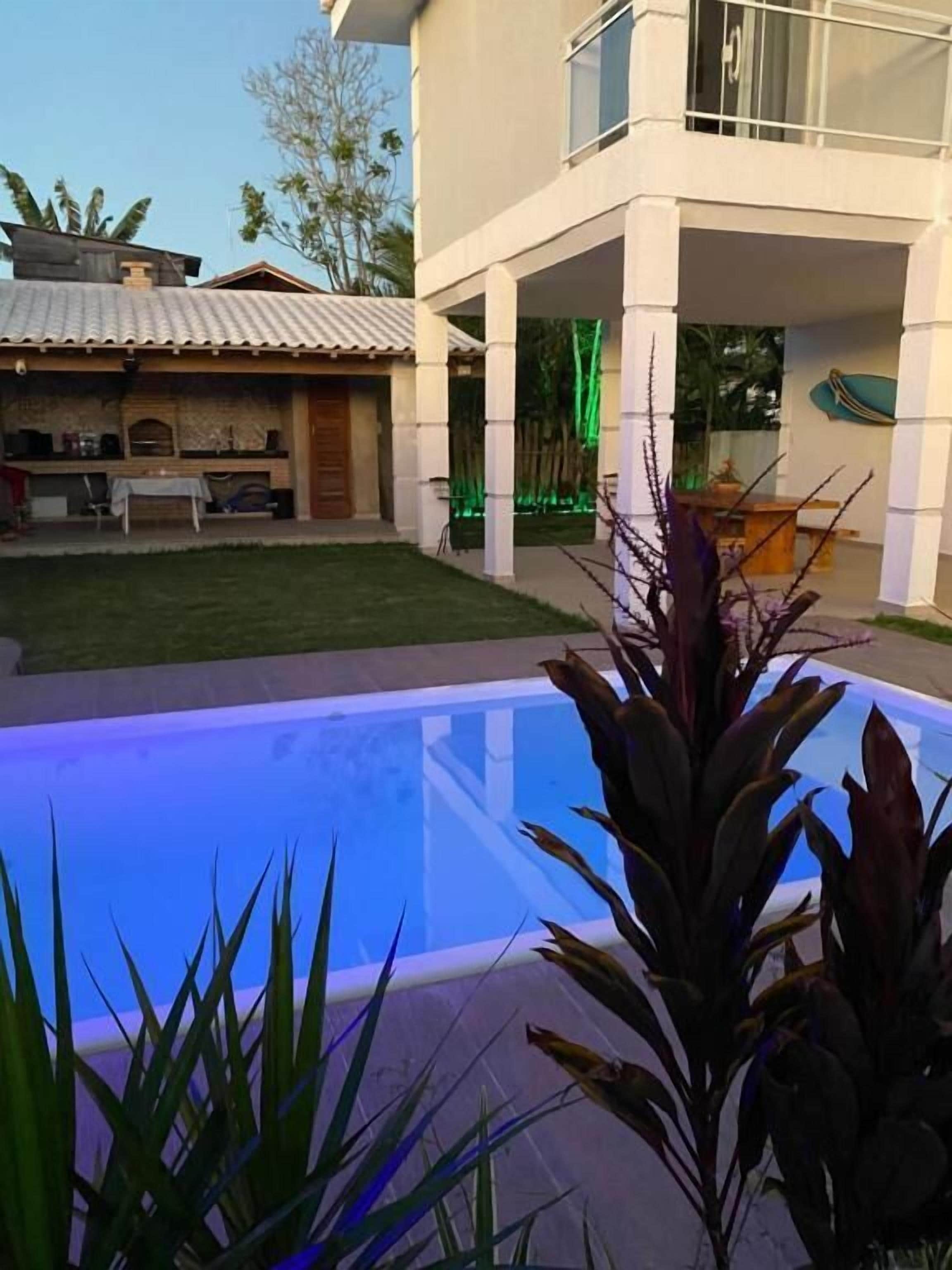 A modern house with a swimming pool, a patio area, and a garden.