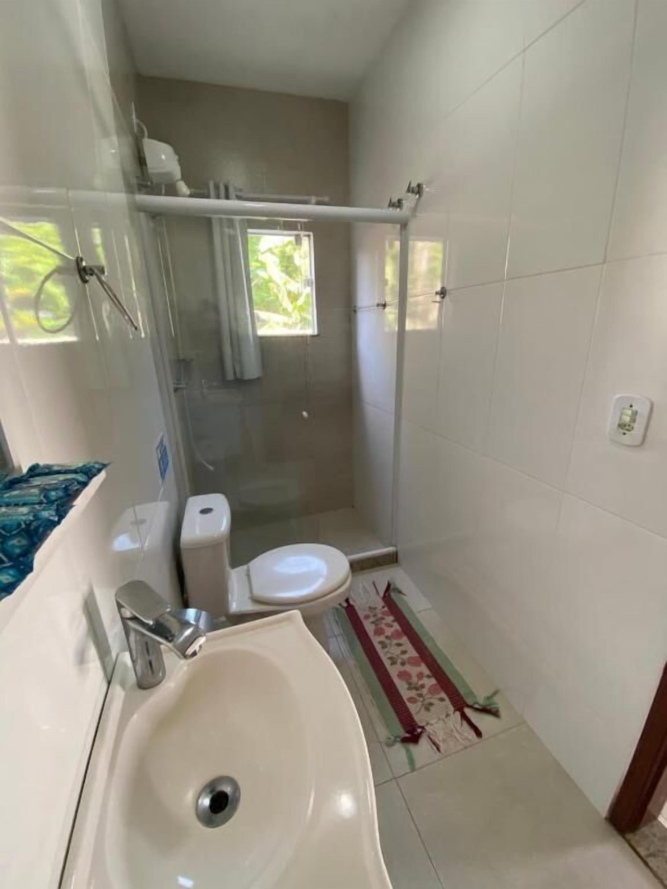 Une salle de bain avec une douche, des toilettes, un lavabo et une fenêtre.