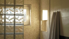 Ein Badezimmer mit gefliesten Wänden, einem Fenster mit Blick und einem Handtuchhalter.