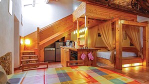 Eine rustikale Holzhütte mit Küche, Essbereich und Schlafempse.