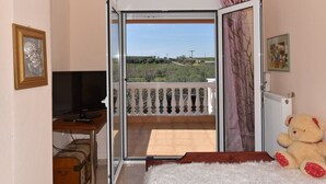 Habitació amb televisió, un os de peluix i un balcó amb vistes.