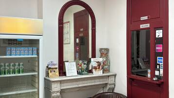 A reception area with a marble fireplace, a vending machine, and a brown leather chair.