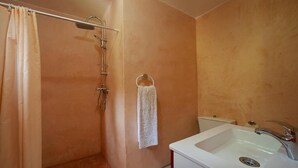 Ein Badezimmer mit Dusche, Waschbecken und Toilette.