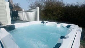 A hot tub with a clear blue water surface, a control panel, and a white exterior. - Yorkshire Lodge with Hot tub (york)
