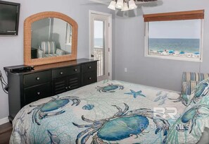 A bedroom with a large bed, a dresser, a mirror, a window with a beach view, and a door leading to a balcony. - Big Surf 1E 2D - Gulf View Beach Pool and Fun (Gulf Shores)