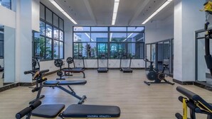 A gym with weightlifting equipment, treadmills, and exercise bikes. - The magical view condo kilimani (Nairobi)