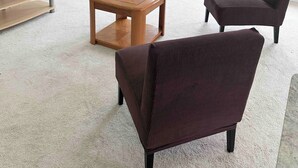 A living room with a flat-screen TV, a wooden coffee table, two brown armchairs, and a large window with curtains. - Room-ensuite Room in 3 Bedroom Townhouse (Brampton)