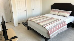 A bedroom with a bed, a desk with a computer, and two white doors. - Room-ensuite Room in 3 Bedroom Townhouse (Brampton)