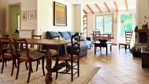 A spacious living area with a dining table, chairs, a sofa, and a fireplace. - Casale del Sole in the hills of Trevignano: pool and nature 5 min. from the Lake! (Monterosi)