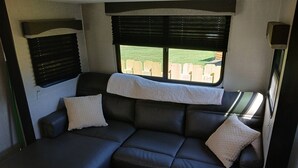 Un sofá modular con vistas a la ventana, un cabecero y una mesita.