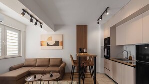 Un salon moderne comprenant un canapé, une table basse et un coin repas avec des chaises.
