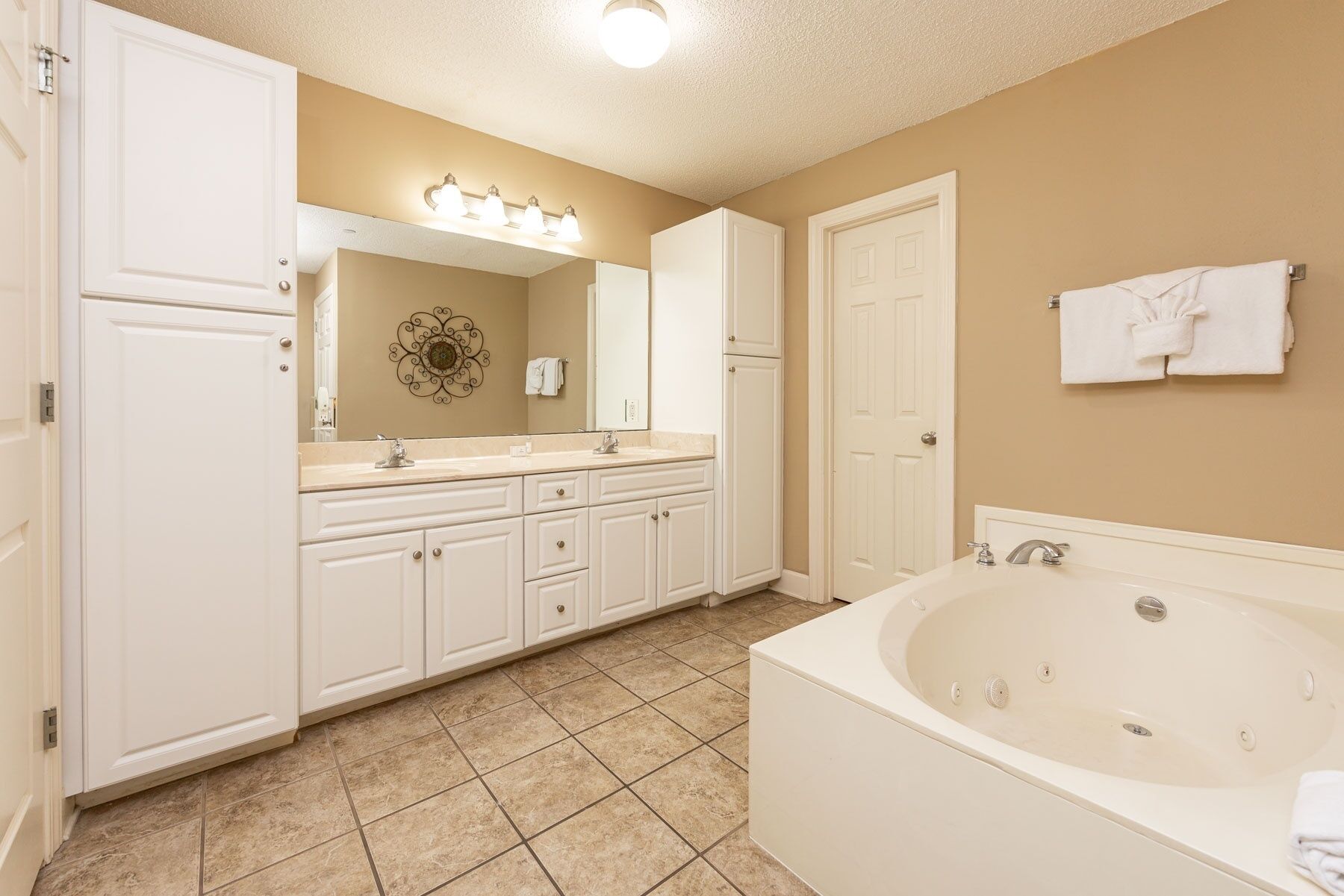 A bathroom with a bathtub, a vanity with a mirror, and a wall-mounted towel rack.