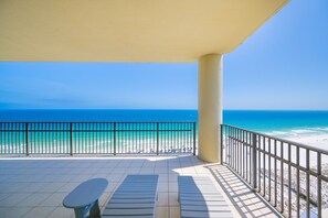 Ein Balkon mit Blick auf das Meer, einem Tisch und Stühlen.