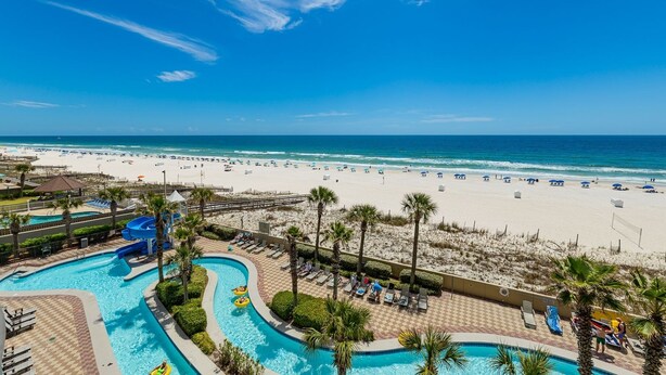 A resort with a pool area, a beach, and a clear blue sky. - Phoenix West 407 3 Bedroom Condo (Orange Beach)