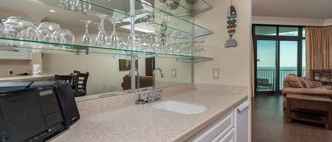 Una cocina moderna con una vinoteca de cristal, un espejo grande y un comedor con vistas.