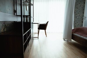 Un dormitorio con cama, escritorio y silla.