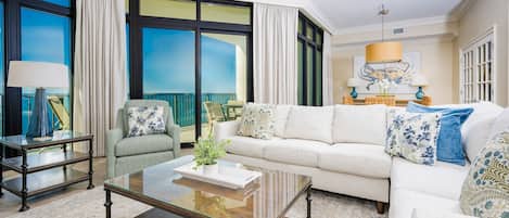 A spacious living room with a large window, a sofa, a coffee table, and a chair.
