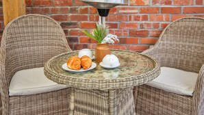 Wicker chairs, a glass table, a brick wall, and a metal lamp. - Y Golchdy (Llangadog)
