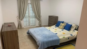 A bedroom with a bed, a wooden nightstand, a dresser, and a window with curtains. - Rural Villa with Private Pool near Vilamoura (Quarteira)