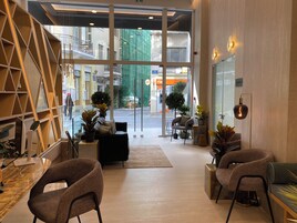 Un intérieur moderne avec des sièges, un escalier et une vue sur la rue.