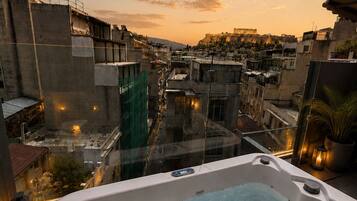A hot tub with a cityscape view at sunset.
