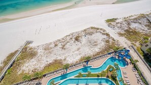 A resort with a large pool, beach access, and a water slide. - The Oasis 1503 Formerly Phoenix West Ii 1503 3 Bedroom Condo (Orange Beach)