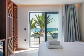 A bedroom with a bed, a sliding glass door to a balcony, and a view of the ocean. - Del Mare (Bali)