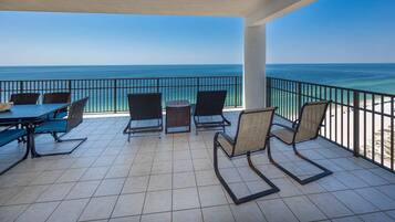 A covered outdoor seating area with a view of the ocean.