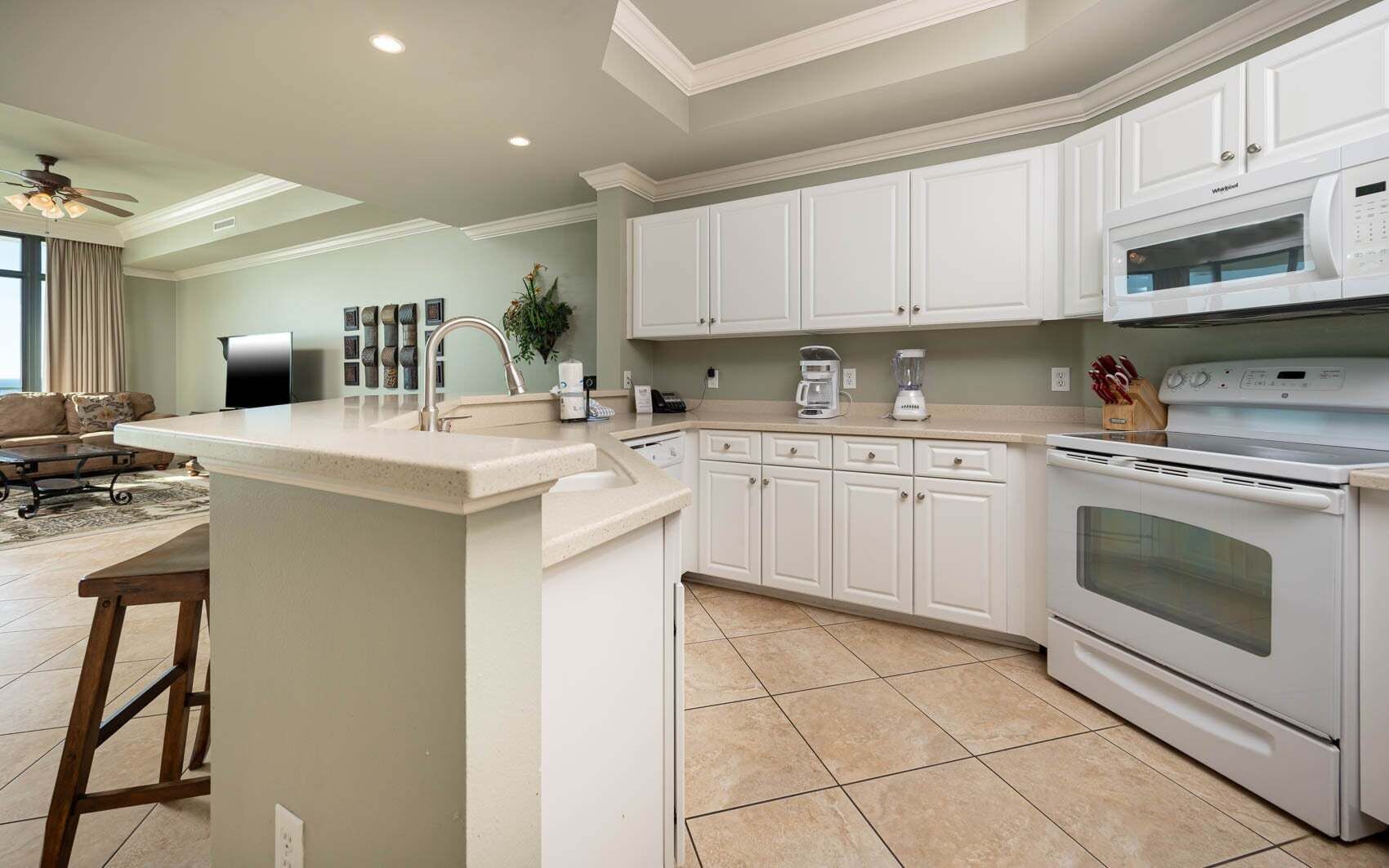 A modern kitchen with white cabinetry, a built-in oven, and a microwave.
