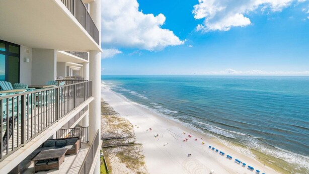 A beachfront hotel with a balcony, outdoor seating, and a view of the ocean. - The Oasis 2204 Formerly Phoenix West Ii 2204 3 Bedroom Condo (Orange Beach)