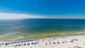A beach with rows of blue umbrellas and a sandy shore. - The Oasis 1607 Formerly Phoenix West Ii 1607 3 Bedroom Condo (Orange Beach)
