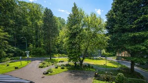A paved pathway leading to a building with a modern design, surrounded by lush greenery and trees. - Bendorf Hotel by Belvilla Double Room With Balcony (Bendorf)