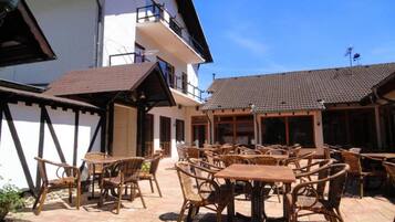 A building with a balcony and outdoor seating area with wicker furniture.
