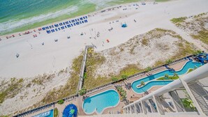 Vista aérea de uma praia com piscina e espreguiçadeiras.