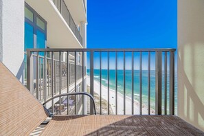 A balcony with a view of the ocean, a chair, and a table. - The Oasis 1907 Formerly Phoenix West Ii 1907 3 Bedroom Condo (Orange Beach)
