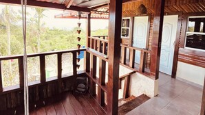 A covered outdoor area with wooden railings, a hanging light fixture, and a view of the outdoors. - Charming Villa in Cabrera With Ocean View (Cabrera)