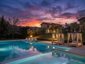 A swimming pool with lounge chairs and a gazebo, set against a sunset sky. - Large and beautiful villa with swimming pool in the Tuscan hills (Fucecchio)