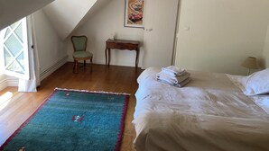A bedroom with a bed, a chair, a desk, a window, and a door. - Chateau à 20 min du circuit des 24H (Soulitré)