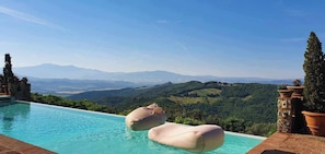 An infinity pool with a view of a mountainous landscape. - Poggio alla Rocca (Civitella Paganico)