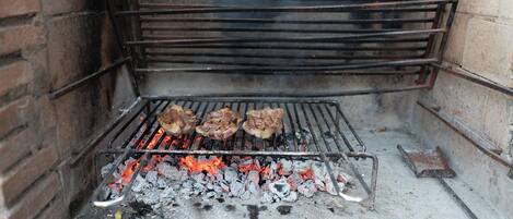 A grill with meat being cooked over charcoal.