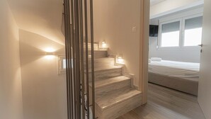A modern interior with a staircase, a bed, and a window. - Villa Magdalena by RentalsPro - Nikiti Halkidiki (Νικήτη)