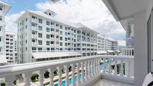 Un hotel moderno con varios pisos, balcones y una zona de piscina.